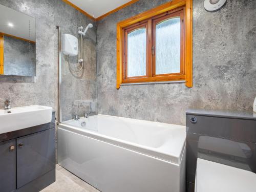 a bathroom with a white tub and a sink at Divach Lodge at Lochletter Lodges in Drumnadrochit