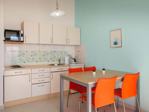a kitchen with a table and orange chairs at Apartment Ivana by Interhome in Senj