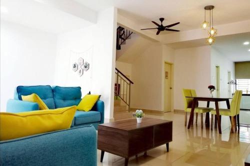 sala de estar con sofá azul y mesa en Desaru Sweet and Cozy Home,11pax, Mini Pool, Beach ,Waterpark, Wifi, BBQ, en Bandar Penawar
