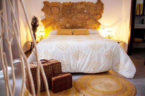 una camera con un letto bianco e una grande testiera del letto di Finca El Jaral a Santa Elena