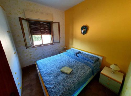 um quarto com uma cama azul e uma janela em Villa Parco Morello Piano Terra em Villarosa