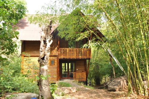 a wooden cabin in the middle of a forest at Uravu Bamboo Grove Resort in Wayanad