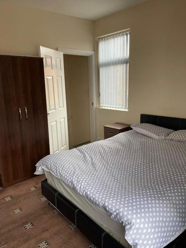 a bedroom with a large bed and a window at 1 Bedroom Flat - Milligan Road in Leicester