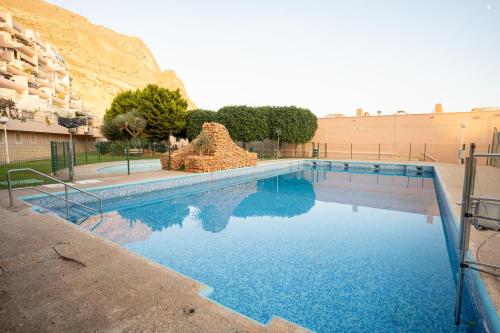 a swimming pool in front of a mountain at TrendyHomes Puerto - Vistas al mar, parking incluido, playa a un paso in Aguadulce
