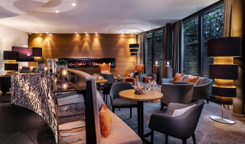 a restaurant with tables and chairs and a fireplace at Romantik Berghotel Astenkrone in Winterberg