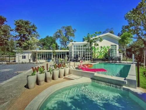 a home with a swimming pool and a house at Utapao sattahip rayong resort in Ban Nong Sa