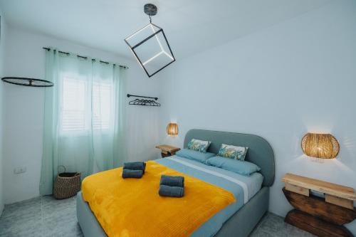 1 dormitorio con 1 cama con manta amarilla en Casa Allegranza, en Cotillo