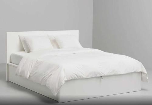 a white bed with white sheets and pillows at Kusama All New Business Grade Comfort Apartment in Belgrade