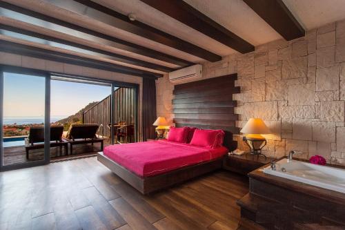 Schlafzimmer mit einem Bett und einer Badewanne sowie Aussicht in der Unterkunft Manaspark Deluxe Hotel in Oludeniz