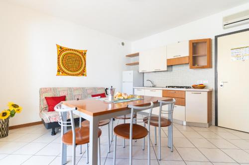 een keuken met een tafel en stoelen in een kamer bij Ca' Mira Apartments in Caorle