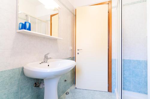 een badkamer met een wastafel en een spiegel bij Ca' Mira Apartments in Caorle