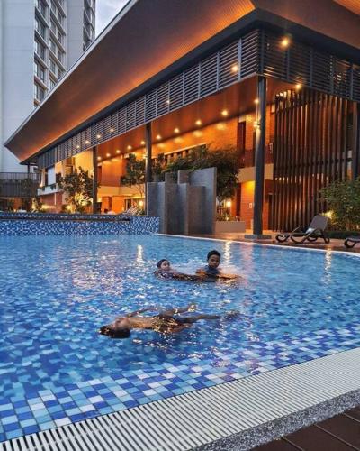 a person laying in a swimming pool in a building at The Glass Homestay Putrajaya in Putrajaya