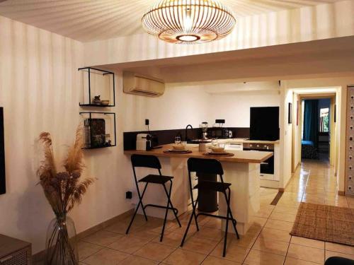 - une cuisine avec un comptoir et des tabourets dans une pièce dans l'établissement Oasis de 42 m2 I Cosy I Cœur de ville I Lit 160x200, à Vaison-la-Romaine