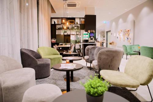 a waiting room with chairs and tables at Aparthotel Adagio Access Freiburg in Freiburg im Breisgau