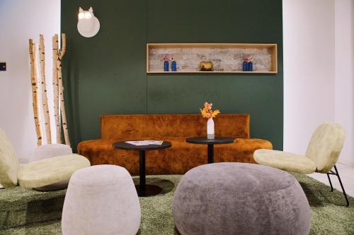 a living room with a couch and a table and chairs at Aparthotel Adagio Access Freiburg in Freiburg im Breisgau