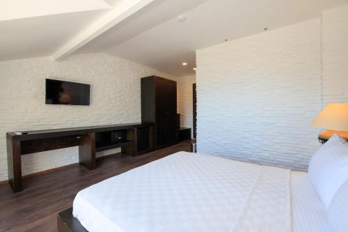 a bedroom with a bed and a tv on a wall at Manaspark Deluxe Hotel in Oludeniz