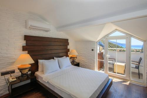 a bedroom with a large bed and a balcony at Manaspark Deluxe Hotel in Oludeniz