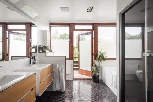 een badkamer met 2 wastafels, een bad en een toilet bij Exclusive Lakefront Mansion with pools in Stockholm in Tyresö