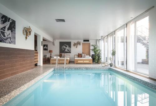 a swimming pool in a house with a living room at Exclusive Lakefront Mansion with pools in Stockholm in Tyresö
