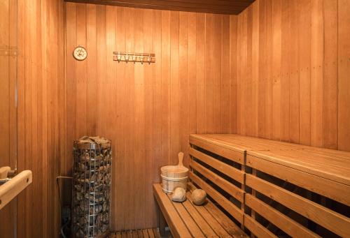 a sauna with a bench and a clock on the wall at Exclusive Lakefront Mansion with pools in Stockholm in Tyresö