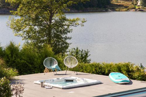 a swimming pool with two chairs on top of a house at Exclusive Lakefront Mansion with pools in Stockholm in Tyresö