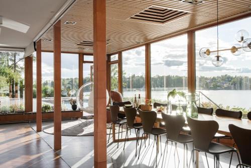 a dining room with a table and chairs and a large window at Exclusive Lakefront Mansion with pools in Stockholm in Tyresö