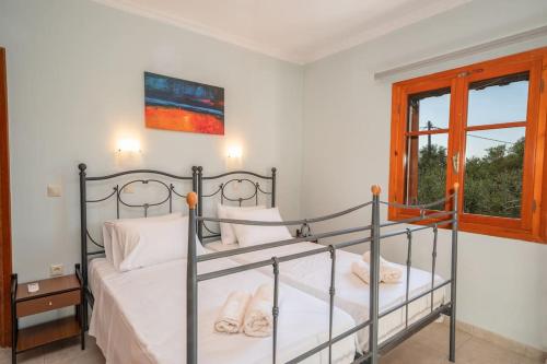 a bedroom with two beds and a window at Afroditi Holiday Home- Green View Apartment in Svoronata