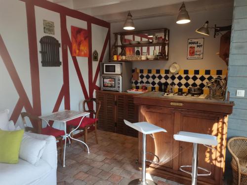 a kitchen with a counter and chairs in a room at Charmant gîte duplex du bon accueil in Trôo