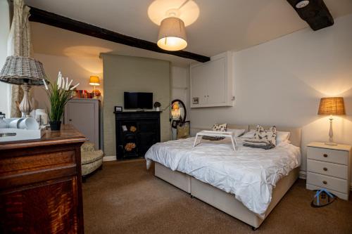 a bedroom with a bed and a desk and a table at The Old Plough, mix of 1 bed and 3 bed units, rustic charm, super king bed or twins, en-suite, secure parking in Caldecott