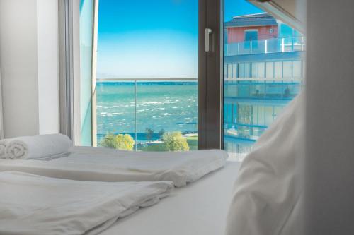 sypialnia z 2 łóżkami i dużym oknem w obiekcie MF Casa Coral Apartment w Siófoku