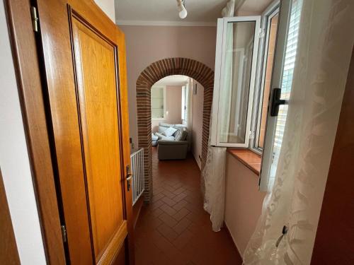 a hallway with a door and a room with a couch at La Casa Di Emma in Lucca