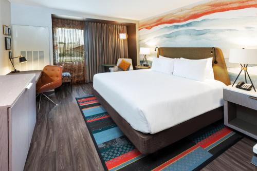 a hotel room with a large bed and a desk at Hotel Indigo Spring - Woodlands Area, an IHG Hotel in Spring