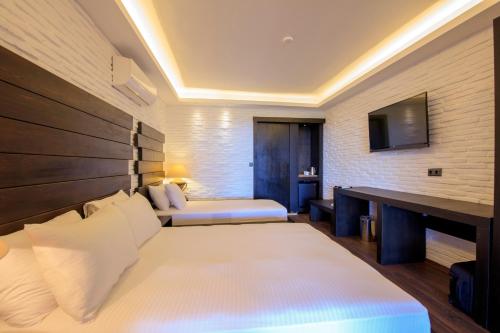 a hotel room with two beds and a television at Manaspark Deluxe Hotel in Oludeniz