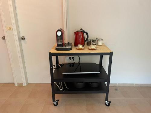 a kitchen cart with a coffee maker on top of it at Alma BaHar - charming 2 bdrm house with garden עלמה בהר - דירת אירוח בלב גן פורח in Zikhron Ya‘aqov