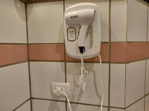 a white phone on a wall with a charger at Tunis Lake View in ‘Izbat an Nāmūs