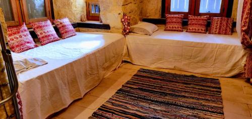 two beds in a room with a rug at Tunis Lake View in ‘Izbat an Nāmūs