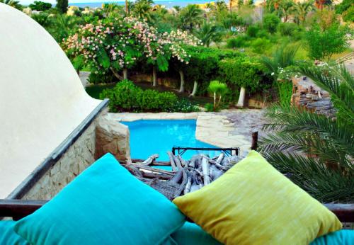 a view of a swimming pool with blue pillows at Tunis Lake View in ‘Izbat an Nāmūs