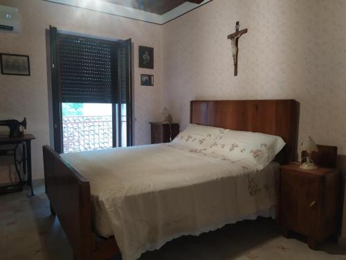 1 dormitorio con 1 cama con una cruz en la pared en Il Pittore - Guest House, en Valsinni