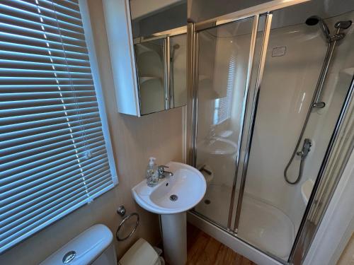 une salle de bain avec douche et lavabo dans l'établissement Bittern 8, Scratby - California Cliffs, Parkdean, sleeps 8, free Wi-Fi, bed linen and towels included, pet friendly - 2 minutes from the beach!, à Scratby