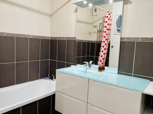 a bathroom with a sink and a mirror and a tub at Appartement Cambo-les-Bains, 2 pièces, 2 personnes - FR-1-495-87 in Cambo-les-Bains