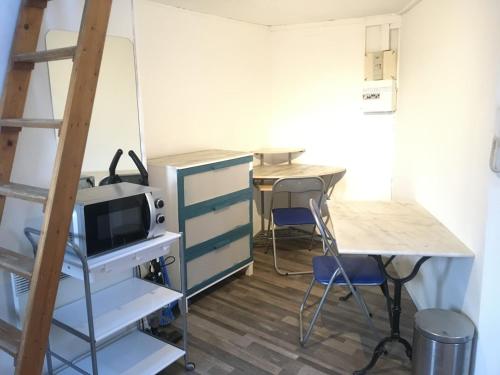 a room with two desks and a desk with a microwave at Studio Gambetta Republique in Lille