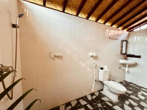 a bathroom with a toilet and a sink at Bataran Garden Cottage in Nusa Penida