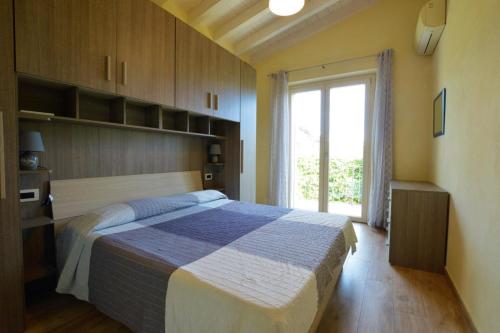 a bedroom with a large bed and a window at La Sassaiola by Nicola Real Estate in Corsanico-Bargecchia