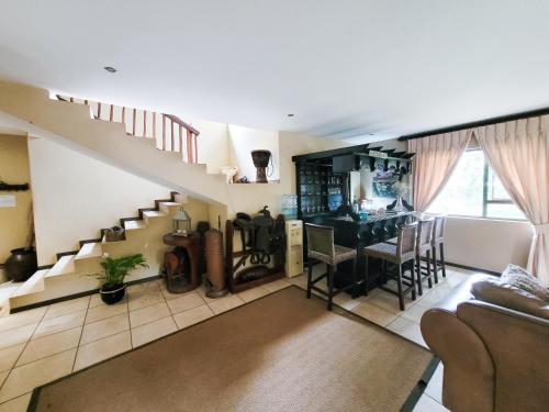 a living room with a staircase and a table at Blue Hills Lodge in Midrand