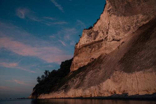 a cliff next to the water at sunset at Villa Huno in Borre