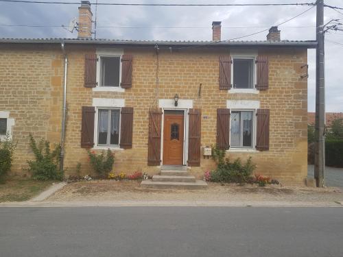 una casa de ladrillo con puerta marrón y porche en CHAMBRE PRIVÉE à LA FERME, 