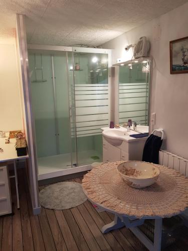bagno con lavandino, doccia e tavolo di CHAMBRE PRIVÉE à LA FERME 