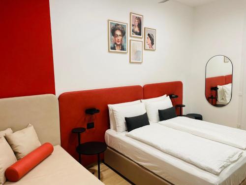 een slaapkamer met een bed en een rood hoofdeinde bij House of Bruno Apartments - Only self check-in in Trento