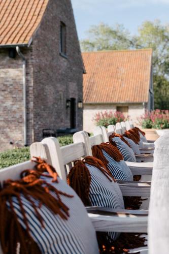 a row of white chairs sitting in front of a building at The Shepherds Farm in Heuvelland