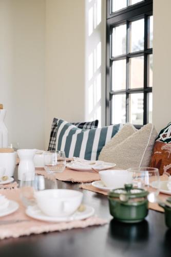 a table with plates and bowls on a couch at The Shepherds Farm in Heuvelland